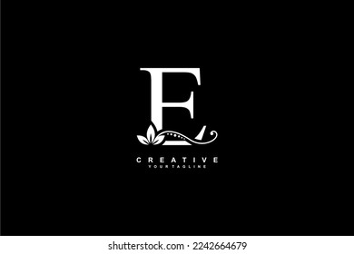 beautiful luxury logo design initial white letter E with gorgeous flourish ornament. monogram typography letter E with gold leaf and floral ornament decoration