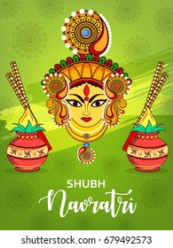 Beautiful Maa Durga face with Dandiya and Kalash on decorative green background for the festival of shubh Navratri .