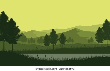 Beautiful mountain view at dusk in the countryside with the silhouettes of trees and lake around it