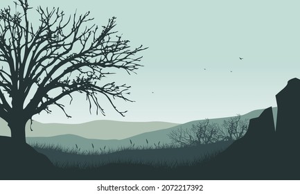 Beautiful mountain views with dry tree silhouettes from the outskirts of the city at sunrise. Vector illustration of a city