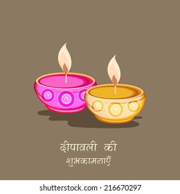 Beautiful oil lit lamps on brown background with wishes of Diwali in Hindi text on brown background.