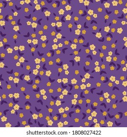 Beautiful pattern in a small flower. Small yellow orange flowers on a purple background. Ditsy flower background. Elegant template for fashionable prints.