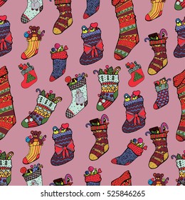 Beautiful purple Christmas background with colorful knitted socks and stockings filled with gifts and sweets. Christmas in boho style. The outline of the painted hands