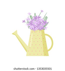Beautiful purple field flowers bouquet in cute watering pot over white