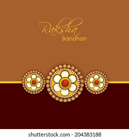 Beautiful rakhi on brown and maroon background for Happy Raksha Bandhan celebrations. 