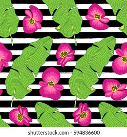 Beautiful seamless green botanical background as bright tropical flowers and banana palm tree leaves for your decoration