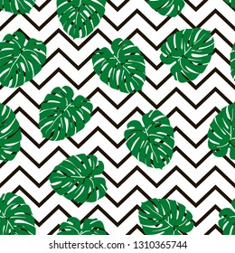 Beautiful seamless pattern with green tropical leaf on a black zig zag background, trendy fashion textile print, pop art design. Retro 80s style.