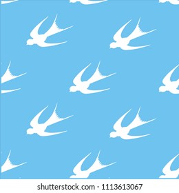 A beautiful seamless pattern. On which there is a white silhouette of swallows on a blue background. It is possible to apply for fabrics and paper.