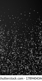 Beautiful snowfall Christmas background. Subtle flying snow flakes and stars on black background. Amazing winter silver snowflake overlay template. Original vertical illustration.