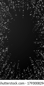 Beautiful snowfall Christmas background. Subtle flying snow flakes and stars on black background. Admirable winter silver snowflake overlay template. Interesting vertical illustration.