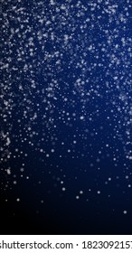 Beautiful snowfall Christmas background. Subtle flying snow flakes and stars on dark blue background. Amazing winter silver snowflake overlay template. Divine vertical illustration.