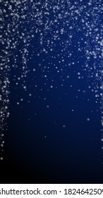 Beautiful snowfall Christmas background. Subtle flying snow flakes and stars on dark blue background. Alluring winter silver snowflake overlay template. Classic vertical illustration.