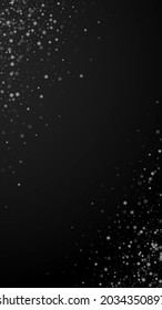 Beautiful snowfall Christmas background. Subtle flying snow flakes and stars on black background. Adorable winter silver snowflake overlay template. Creative vertical illustration.