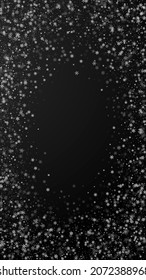 Beautiful snowfall Christmas background. Subtle flying snow flakes and stars on black background. Actual winter silver snowflake overlay template. Delicate vertical illustration.