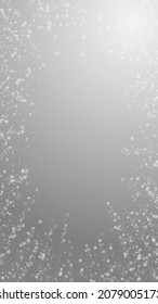 Schöner, schneebedeckter Weihnachtshintergrund. Subtile fliegende Schneeflocken und Sterne auf grauem Hintergrund. Bewundernswerte Winterschneeflocke. Gefällige vertikale Abbildung.
