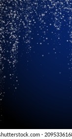 Hermoso fondo navideño de nevadas. Sutiles copos de nieve volando y estrellas en un fondo azul oscuro. Plantilla de superposición de copos de nieve de plata en invierno vivo. Ilustración vertical inusual.