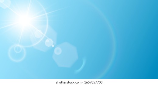 Beautiful sun with many different flares and sparkles, rainbow halo, on blue sky background