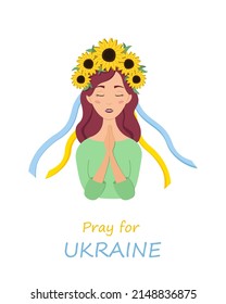 Beautiful ukrainian woman in a wreath with sunflowers prays for Ukraine. Stop war.