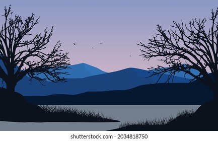 The beautiful view of the mountains from the riverbank at dusk with the silhouette of dry trees around it. Vector illustration of a city