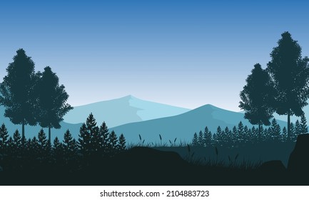 Beautiful view of silhouetted mountains with pine trees from the countryside at dusk