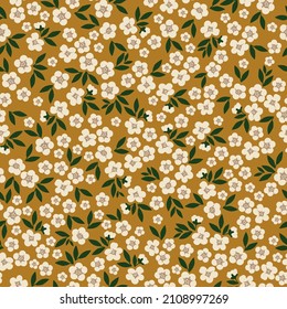 Beautiful vintage pattern. White flowers, dark green leaves. Mustard background. Floral seamless background. An elegant template for fashionable prints.