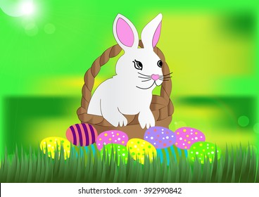Beautiful white Easter bunny in the wicker basket on the grass background with easter colored eggs
