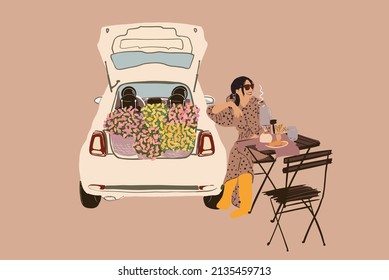 Hermosa mujer con ropa y botas de goma sentada cerca de la mesa y bebiendo una bebida caliente mientras hace un picnic cerca de un auto lleno de flores. Ilustración del vector