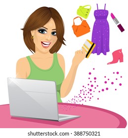 beautiful woman shopping online using a laptop with her credit card buying some fashion goods