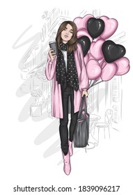 A beautiful woman in a stylish coat, scarf, jeans and boots. Fashionable clothes and accessories, fashion and style. Heart shaped balloons. Valentine's Day.