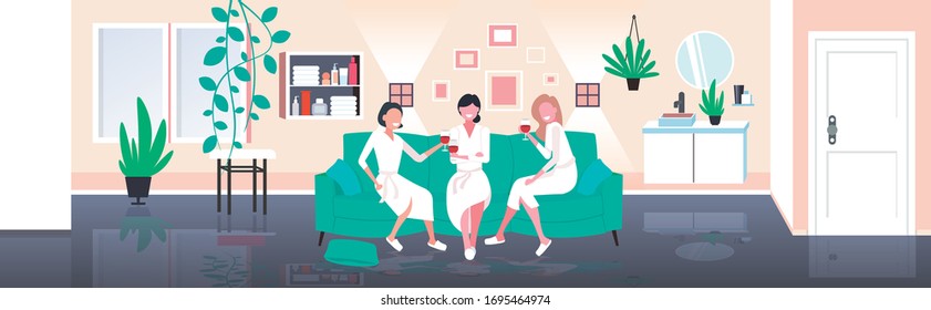 beautiful women in bathrobes drinking wine having fun home care concept girls sitting on sofa relaxing during bachelorette party modern living room interior full length horizontal vector illustration