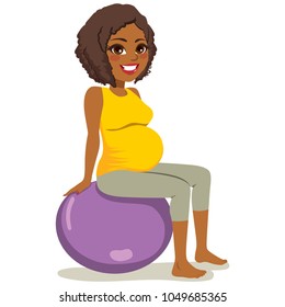 Beautiful young African American woman pregnant exercising yoga with fitness ball