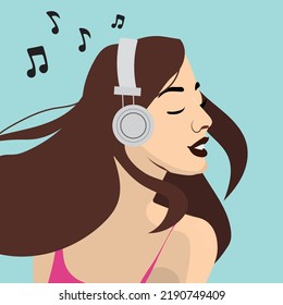 Beautiful young brunette woman listening music with headphones.