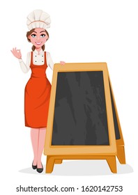 Beautiful young chef woman standing near blank menu blackboard. Pretty cook lady in professional apron and hat. Stock vector illustration