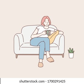 Beautiful young woman sitting on sofa at home with cup. Hand drawn style vector design illustrations.