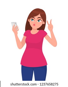 Beautiful young woman taking selfie with smartphone and gesturing victory, V or peace sign. Modern lifestyle,  human emotions and body language concept illustration in vector cartoon flat style.