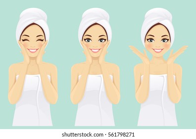 Beautiful young woman in towel with clean fresh skin touch own face