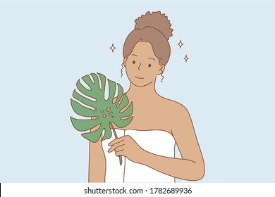 Beauty, makeup, ecology, advertising concept. Young happy smiling african american woman girl cartoon character standing in towel and green leaf looking at camera. Bio or eco creams and oils promotion