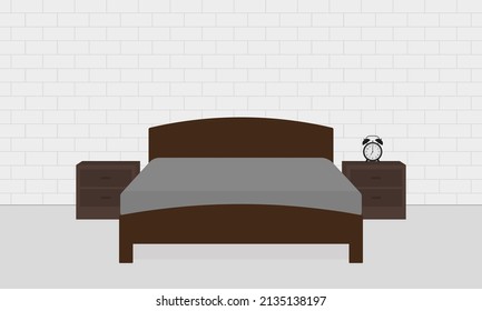 Bed and bedside tables with alarm clock in a room with a brick wall