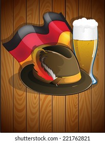 Beer glass, German flag and  Oktoberfest hat with feathers on a wooden background. Abstract Oktoberfest  background 
