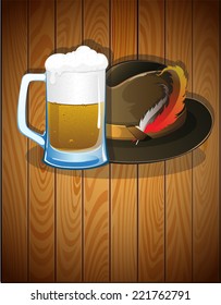 Beer glass, and  German Oktoberfest hat with feathers on a wooden background. Abstract Oktoberfest  background 