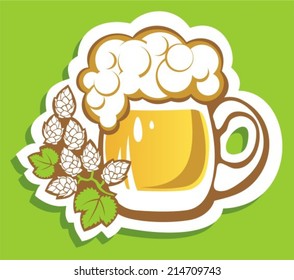 Beer glass and hops on a green background.