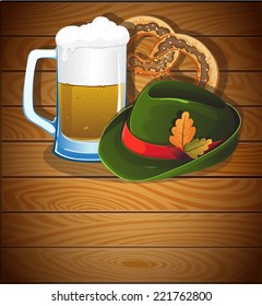 Beer glass, pretzel and  German Oktoberfest hat with oak leaves on a wooden background. Abstract Oktoberfest  background 