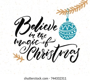 Believe in the magic of Christmas. Calligraphy caption for greeting cards and gift tags. Hand drawn illustration of Christmas tree branch with blue ball