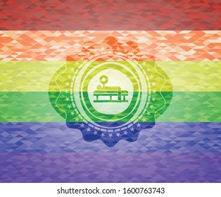 bench press icon inside emblem on mosaic background with the colors of the LGBT flag