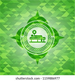 bench press icon inside green emblem with triangle mosaic background