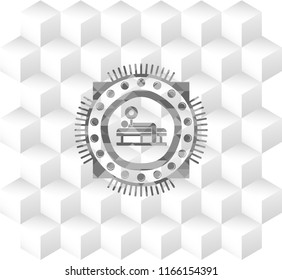 bench press icon inside grey badge with geometric cube white background