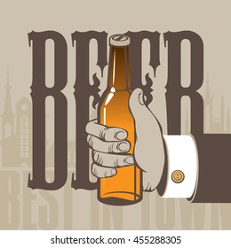 best beer in town. Hand with a bottle on the background of the old town