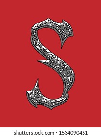 Beveled letter with coarse surface on red background.