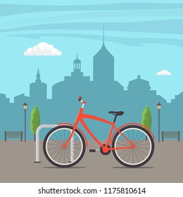 Bicycle Parking on a city street. Bike on urban background. Cute red bicycle, parked in the city, with skyscrapers in the background, trees, lights and benches. Vector flat illustration