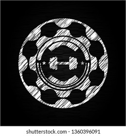 big dumbbell icon inside chalk emblem written on a blackboard